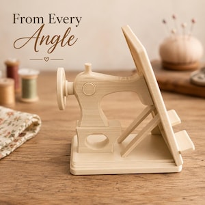 May include: A light-colored wooden stand shaped like a vintage sewing machine with a flat angled support for holding items. The text "From Every Angle" is visible in the upper left corner above the wooden sewing machine structure.