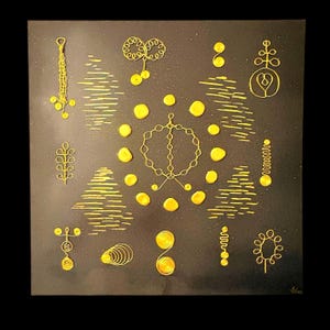 May include: Square black canvas art featuring a collection of gold-colored wire and paint designs. The artwork includes various shapes such as circles, lines, and abstract floral-like forms. The background has a speckled texture.