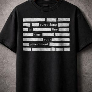 Peut inclure: Une tasse en céramique blanche avec une anse noire et l'inscription "But First, Coffee" en noir, dans une police manuscrite. La tasse est posée sur une surface blanche.