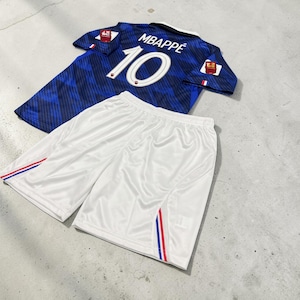 Può includere: Una maglia da calcio blu con un motivo diagonale blu scuro, che riporta il nome MBAPPÉ e il numero 10 in bianco sul retro, abbinata a pantaloncini sportivi bianchi con dettagli a righe rosse, bianche e blu lungo le cuciture laterali.