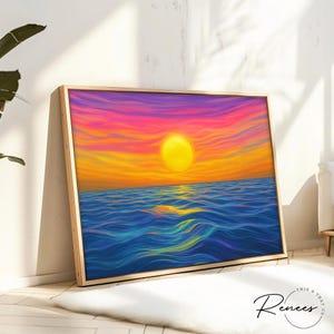 May include: A framed art print depicts a vibrant sunset over the ocean. The artwork features a large yellow sun, orange and pink sky, and blue water. The frame is a light wood color. The artist's signature is in the bottom right corner.