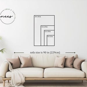Puede incluir: Un sal&oacute;n con un sof&aacute; crema, cojines y una manta. Un diagrama en la pared muestra los tama&ntilde;os de arte potenciales: 61x91 cm, 41x61 cm, 30x46 cm y 20x30 cm. El texto dice "sofa size is 90 in (229cm)." Tambi&eacute;n se ven una planta y una mesa auxiliar.