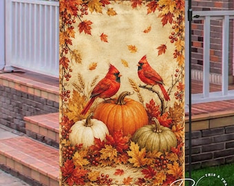 May include: A rectangular garden flag featuring two red cardinal birds perched near three pumpkins of varying sizes. The scene is framed by autumn foliage in shades of orange, yellow, and red, set against a textured, light beige background.