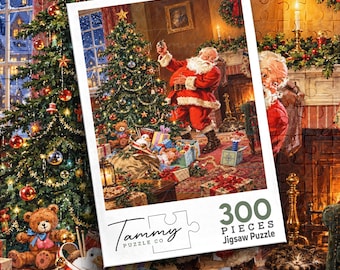 May include: A 300-piece jigsaw puzzle box featuring a festive illustration of Santa Claus decorating a Christmas tree in a cozy living room. The box displays the Tammy Puzzle Co logo, the piece count, and a scene with gifts and a teddy bear.