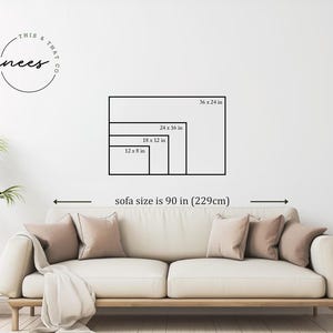 May include: A living room scene with a cream-colored sofa, pillows, and a throw blanket. The wall displays framed art size options: 36 x 24 in, 24 x 16 in, 18 x 12 in, and 12 x 8 in. The sofa size is 90 in (229cm). A plant in a woven basket is on the left.