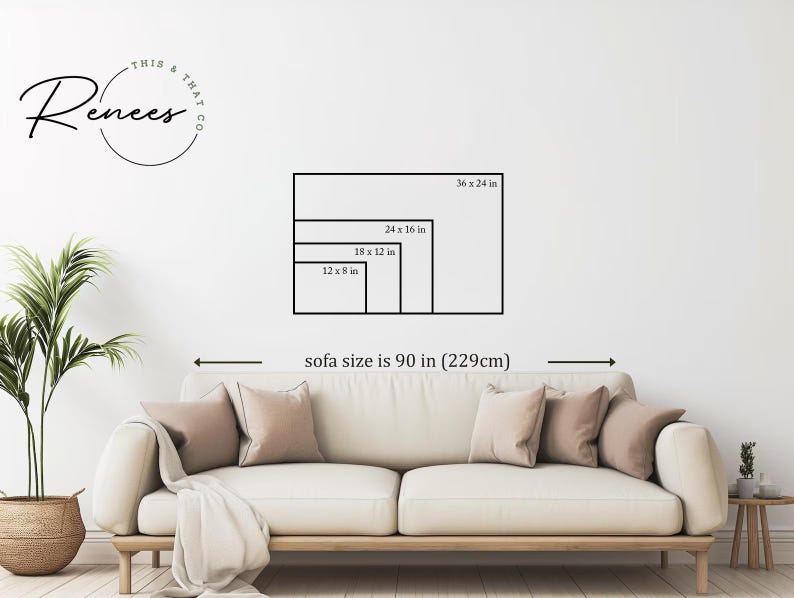 May include: A living room scene with a cream-colored sofa, pillows, and a throw blanket. The wall displays framed art size options: 36 x 24 in, 24 x 16 in, 18 x 12 in, and 12 x 8 in. The sofa size is 90 in (229cm). A plant in a woven basket is on the left.