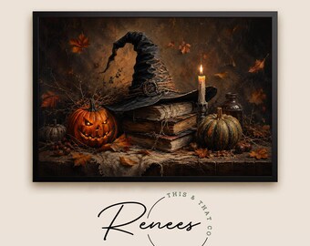 May include: A framed wall art print featuring a black witch hat resting on a stack of old books, an orange jack-o'-lantern, a green pumpkin, a lit candle, and scattered autumn leaves against a dark background. The text This & That Renees is below.