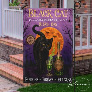 May include: A rectangular garden flag featuring a black cat standing before a large orange moon. The text reads Black Cat Brewing Co. Since 1875, Bat Wing Tonic Elixir, and Potions - Brews - Elixirs. A green absinthe bottle and glass are visible.