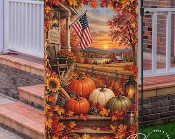 May include: A decorative garden flag featuring a fall harvest scene with orange and white pumpkins, sunflowers, and autumn leaves. A wooden porch with a rocking chair, a lantern, and an American flag are visible under a sunset sky.