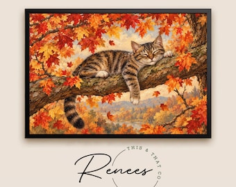 May include: A framed wall art print featuring a brown tabby cat sleeping on a tree branch surrounded by vibrant autumn foliage in shades of red, orange, and yellow. Below the image, the text reads This & That Co. and Renees.