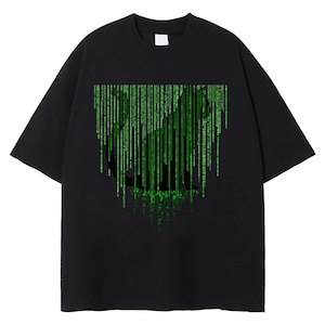 May include: Black t-shirt with a cat silhouette and a green digital rain design. The graphic is a matrix-style pattern of green code. The shirt has a crew neck and short sleeves. The design is reminiscent of the film 'The Matrix'.