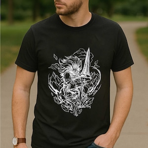 May include: Black t-shirt featuring a white graphic of a warrior holding a sword, surrounded by mountains and clouds. The text "Wildless King" is at the bottom of the design. The shirt has short sleeves and a crew neck.