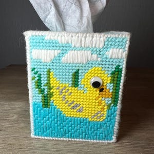 May include: A white ceramic mug with a black handle and the text "But First, Coffee" in a handwritten style. The mug is on a white surface. The mug is approximately 4 inches tall.