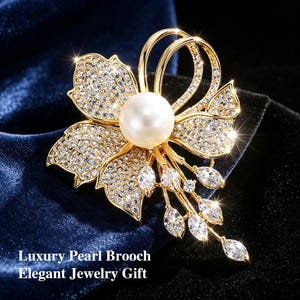 Könnte beinhalten: Ein Set aus drei Keramikbechern mit gesprenkelter, matter Oberfläche. Die Becher sind in den Farbtönen Creme, Hellgrau und Dunkelgrau gehalten. Jeder Becher hat ein schlichtes, minimalistisches Design und einen abgerundeten Griff.