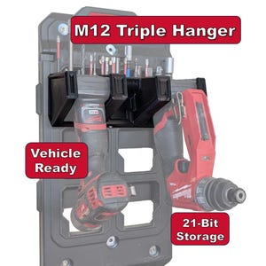 May include: Black M12 Triple Hanger with red and black power tools. The hanger has the text "M12 Triple Hanger", "Vehicle Ready", and "21-Bit Storage". The tools are attached to a gray storage unit.