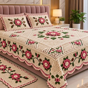 May include: A cream-colored crocheted bedspread and matching rectangular rug featuring three-dimensional pink flowers with white centers and green leaves. The bedspread has a scalloped edge and a central floral motif, complemented by two matching pillow shams.