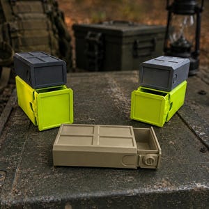 Pu&ograve; includere: Tre contenitori rettangolari con cassetti scorrevoli. Due contenitori presentano una parte superiore grigio scuro con una base verde lime brillante, mentre il terzo &egrave; color beige. Ogni unit&agrave; ha una parte superiore a griglia e una manopola laterale.