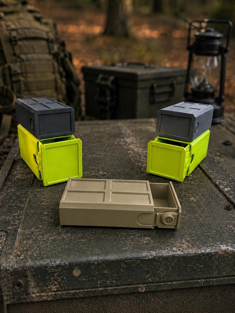 Pu&ograve; includere: Tre contenitori rettangolari con cassetti scorrevoli. Due contenitori presentano una parte superiore grigio scuro con una base verde lime brillante, mentre il terzo &egrave; color beige. Ogni unit&agrave; ha una parte superiore a griglia e una manopola laterale.