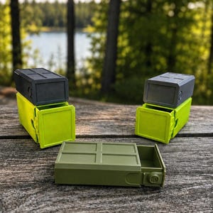 Pu&ograve; includere: Tre contenitori rettangolari con cassetti scorrevoli. Due contenitori sono verde lime con coperchi grigio scuro e uno &egrave; verde oliva. Ogni unit&agrave; presenta un motivo a griglia sulla superficie superiore e una piccola manopola circolare sul lato.
