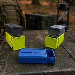 Pu&ograve; includere: Tre contenitori rettangolari con cassetti scorrevoli. Due contenitori presentano una sezione superiore grigio scuro con un cassetto verde lime brillante, mentre il terzo &egrave; interamente blu con un cassetto scorrevole e una manopola laterale.