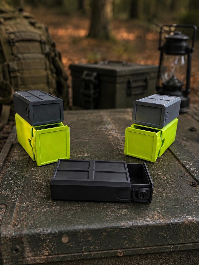Pu&ograve; includere: Tre contenitori rettangolari con cassetti scorrevoli. Due contenitori presentano una parte superiore grigio scuro con un cassetto verde lime brillante, mentre il terzo &egrave; interamente grigio scuro. Ogni unit&agrave; ha una parte superiore a griglia.