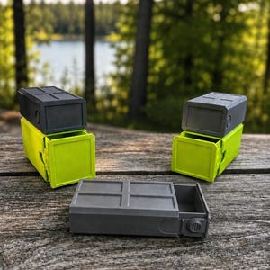 Pu&ograve; includere: Tre contenitori rettangolari con cassetti scorrevoli. Due contenitori sono verde lime con coperchi grigio scuro, posizionati verticalmente. Un contenitore &egrave; grigio scuro con coperchio abbinato, posizionato orizzontalmente in primo piano.