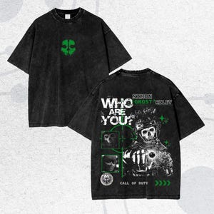 May include: Black t-shirt with a green skull graphic on the front and a larger design on the back featuring a skull soldier, the text "WHO ARE YOU?" and "CALL OF DUTY". The shirt has a vintage, distressed look.