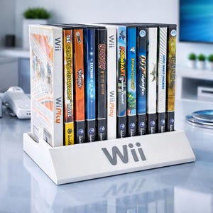 Puede incluir: Una consola Wii blanca y carcasas de juegos se muestran sobre una superficie reflectante. Las carcasas de los juegos están en un soporte blanco con el logotipo de Wii. Las carcasas de los juegos tienen cubiertas coloridas con títulos de juegos como "The SpongeBob SquarePants Movie" y "007 Nightfire".