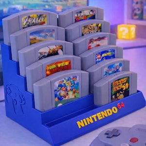 May include: A blue Nintendo 64 game cartridge display stand holding several gray game cartridges. The stand has the Nintendo 64 logo in yellow. A gray controller is in the foreground.