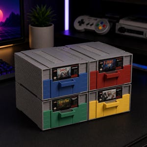May include: A set of four grey storage drawers designed to resemble classic video game cartridges. Each drawer features a colourful front panel in blue, red, green, or yellow, with a slot holding a vintage game cartridge labelled Castlevania, F-Zero, Secret of Mana, or Chrono Trigger.
