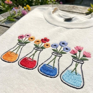 Può includere: Una tazza di ceramica bianca con manico nero e la scritta "But First, Coffee" in nero, in grassetto. La tazza è su una superficie bianca.