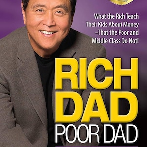May include: Book cover for "Rich Dad Poor Dad" by Robert T. Kiyosaki. The cover features a man smiling, with the title in large yellow letters. The book celebrates 20 years as the #1 personal finance book.