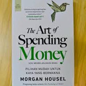 May include: A hardcover book titled "The Art of Spending Money" with a green and black title on a white background. The cover features a green illustration of a bird. The author's name, Morgan Housel, is also displayed.