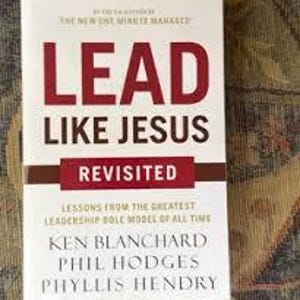 Puede incluir: Un libro de tapa dura titulado "LEAD LIKE JESUS REVISITED" con texto rojo y blanco. La portada del libro incluye los nombres de los autores: Ken Blanchard, Phil Hodges y Phyllis Hendry. El subtítulo del libro dice: "LESSONS FROM THE GREATEST LEADERSHIP ROLE MODEL OF ALL TIME."