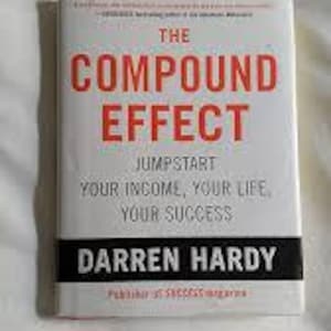 Può includere: Un libro intitolato "The Compound Effect" di Darren Hardy. La copertina è bianca con testo rosso e nero. Il sottotitolo del libro recita "Jumpstart Your Income, Your Life, Your Success."