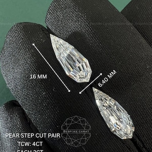 May include: A pair of pear step cut diamonds with a total weight of 4CT, each weighing 2CT. The stones feature a 2.50 ratio, a length of 16 mm, and a width of 6.40 mm. These CVD diamonds are labeled as a pear step cut pair by Bespoke Carat.
