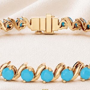 Può includere: Un bracciale tennis in oro con una serie di pietre turchesi rotonde e luminose incastonate in un design a maglie metalliche a forma di S. Il bracciale include una chiusura a cassetta sicura e riporta il testo LyraJewelryGift in basso.