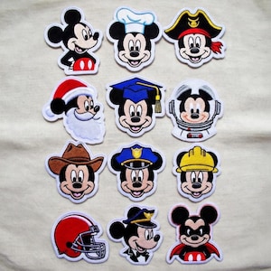 May include: A white ceramic mug with a black handle and the text "But First, Coffee" in a black, bold font. The mug is sitting on a wooden surface.