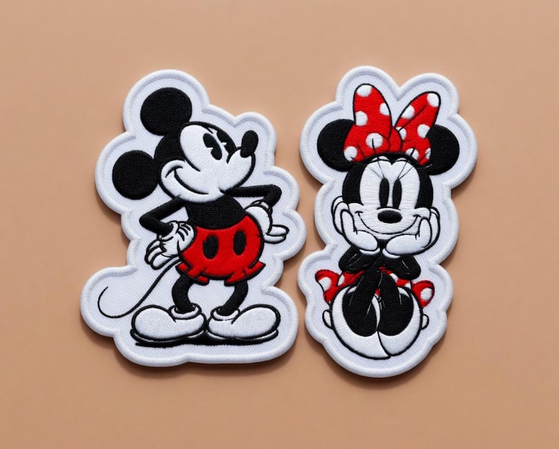 May include: Embroidered patches featuring Mickey Mouse and Minnie Mouse. Mickey is in a standing pose with red shorts. Minnie is seated, wearing a red bow with white polka dots and a red and white polka dot skirt. Both have white outlines.