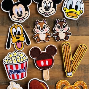 May include: Embroidered patches featuring Disney characters and themed food items. Includes Mickey Mouse, Minnie Mouse, Donald Duck, Pluto, Chip and Dale, popcorn, ice cream, a Mickey-shaped popsicle, churros, a turkey leg, and a Mickey pretzel.