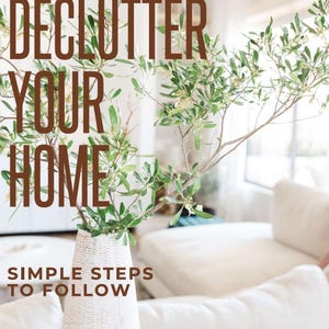 Puede incluir: Un jarrón blanco alto y texturizado contiene ramas de olivo verdes. El texto marrón dice: DECLUTTER YOUR HOME, SIMPLE STEPS TO FOLLOW, Sheila Interior Redesign y sheilainteriorredesign@gmail.com. El jarrón tiene forma cónica y estriada.