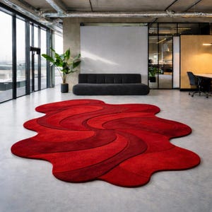 May include: A large, abstract red rug with a flowing, organic design. The rug features varying shades of red, creating a sense of depth and movement. The rug's dimensions are approximately 10 feet by 8 feet.