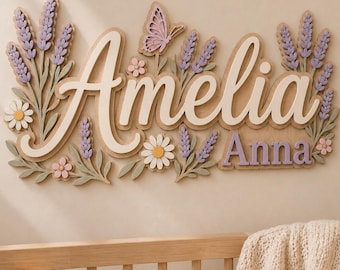 以下が含まれることがあります： 大きな白い筆記体で「Amelia」、小さな紫色のブロック体で「Anna」と書かれた木製の装飾用ウォールサイン。ラベンダーの小枝、デイジー、蝶の形にカットされたパーツが重ねられ、紫、ピンク、緑の色合いで構成されています。