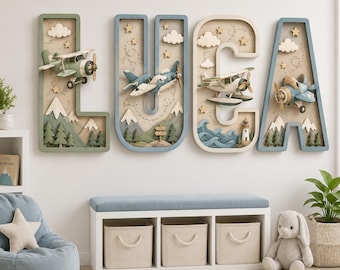 May include: Four large, three-dimensional wall letters spelling LUCA. Each letter features a unique scene with miniature aeroplanes, clouds, stars, mountains, trees, waves, and a lighthouse in shades of blue, green, and cream.