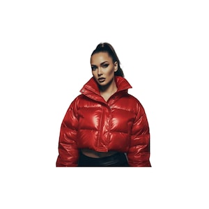 Puede incluir: Chaqueta roja acolchada, brillante y corta, con cuello alto. La chaqueta tiene un acabado brillante y cierre de botón. La modelo lleva un top negro. Una prenda llamativa y moderna.