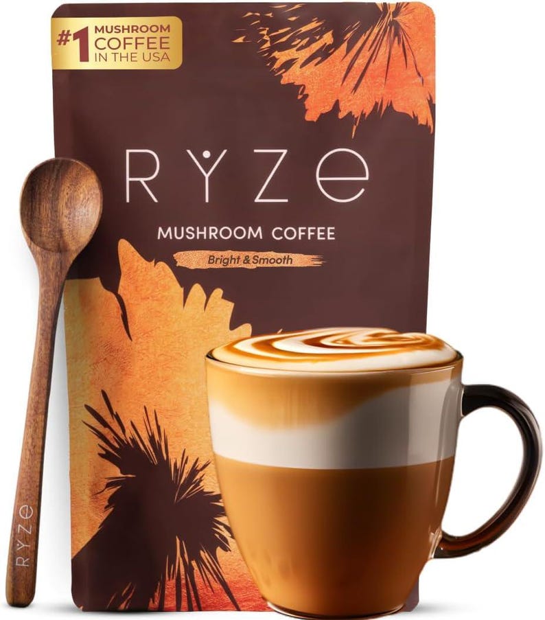 May include: A brown bag of RYZE Mushroom Coffee with a wooden spoon and a mug of coffee. The bag has the text "Mushroom Coffee" and "Bright & Smooth". The mug has a white and brown design with a swirl of foam on top.