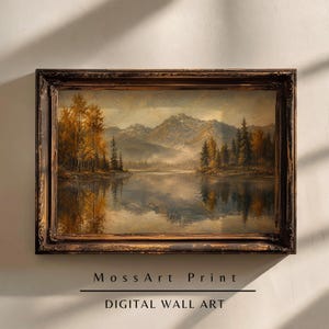May include: A rectangular landscape painting in a dark, distressed ornate frame. The artwork depicts a serene lake reflecting towering mountains and autumn-toned trees in shades of gold and brown. Text below reads Moss Art Print DIGITAL WALL ART.