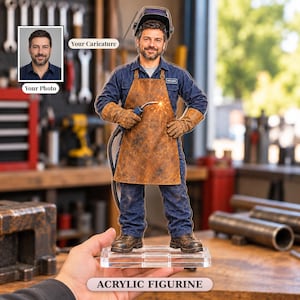 May include: A custom acrylic figurine of a welder wearing a blue uniform, a brown leather apron, and a welding helmet, holding a welding torch. The figure stands on a clear rectangular base. An inset shows a photo of the person depicted.
