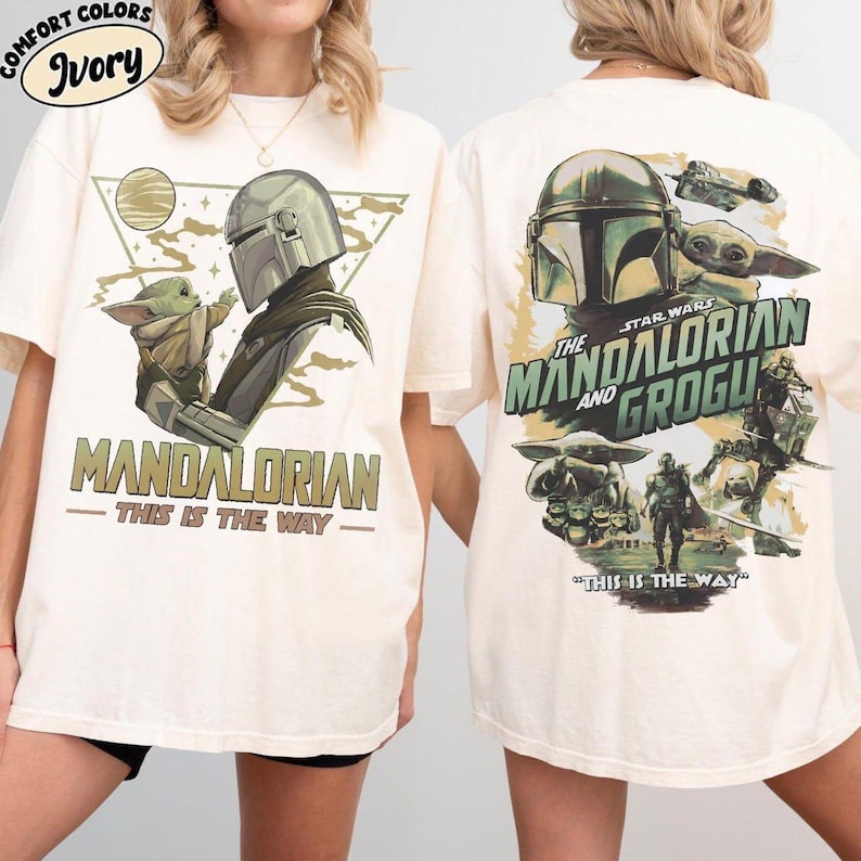 May include: Ivory-colored t-shirts featuring "The Mandalorian and Grogu" graphics. The front design shows the Mandalorian and Grogu, with the text "MANDALORIAN - THIS IS THE WAY." The back design includes the Star Wars logo and additional characters.