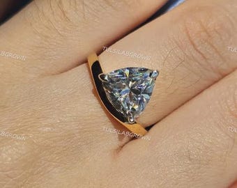 Anillo de compromiso minimalista de oro macizo de tres puntas con diamantes cultivados en laboratorio de talla trillón para uso diario.